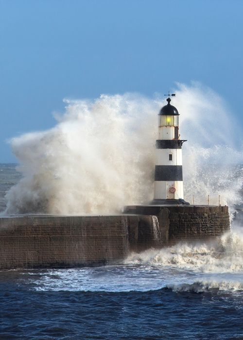 Waves crashing over lighthouse