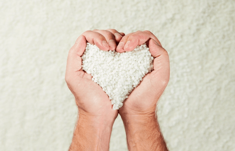 Male hands, heart shaped holding white granulates